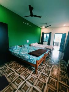 um quarto com 2 camas e uma parede verde em Maanyatha Home Stay em Manipal