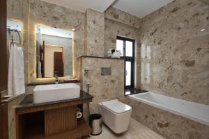een badkamer met een wastafel, een bad en een toilet bij Hotel Grand View in Kathmandu
