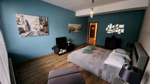 um quarto com uma cama e uma parede azul em Jedynka Apartments em Iwonicz-Zdrój