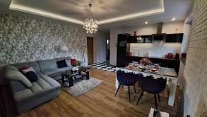 uma sala de estar com um sofá e uma mesa em Jedynka Apartments em Iwonicz-Zdrój