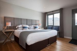 a bedroom with a large bed and a large window at Kylesku Hotel in Kylestrome