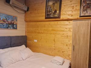 a bed in a room with a wooden wall at Vida Bhermon 2, one small wooden cabin in Majdal Shams