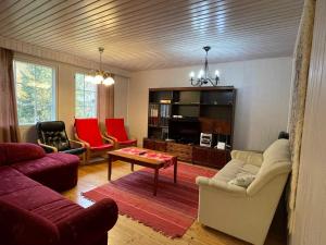 uma sala de estar com um sofá e uma mesa em Villa Red House em Parikkala