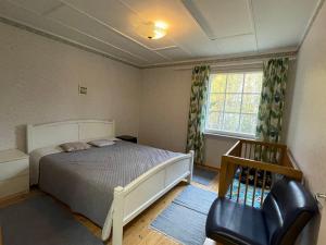 a bedroom with a bed and a chair and a window at Villa Red House in Parikkala