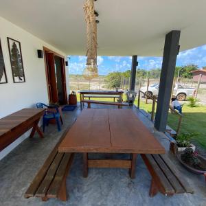 a patio with a wooden table and a picnic table at Sunshine - Casa de praia em Barra Grande -Ba in Barra Grande