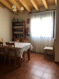 a dining room with a table and chairs and a window at El huerto de Lino in Candeleda +15 photos
