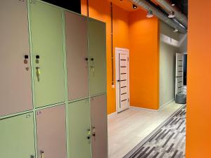 an empty locker room with orange and green lockers at WakeUp Bishkek in Bishkek