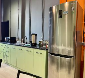 a kitchen with a large stainless steel refrigerator at WakeUp Bishkek in Bishkek