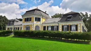 a yellow house with a black roof on a green yard at Schloß Ziegersberg 