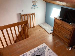 a living room with a staircase and a flat screen tv at Maison Fontrabiouse in Fontrabiouse