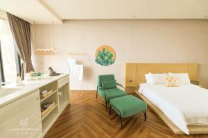 ein Schlafzimmer mit einem Bett und zwei grünen Stühlen in der Unterkunft Wonderwall in Wujie