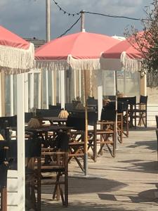 una fila de mesas con sombrillas en un patio en Zee en Duin en Zandvoort