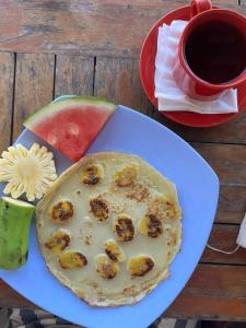 a plate of food with a pizza and a cup of coffee at Nelly homestay in Gili Islands