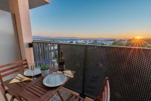 a balcony with a wooden table with a bottle of wine at Grüne Oase an der Therme in Vienna