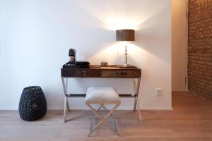 a desk with a chair and a lamp on it at Refugium de Luxe Messe-Deutz in Cologne