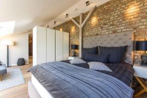 a bedroom with a large bed and a brick wall at Refugium de Luxe Messe-Deutz in Cologne