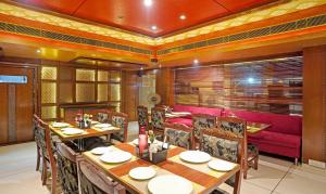 a restaurant with tables and chairs and a red couch at Treebo Trend The Royal CM in Jaipur