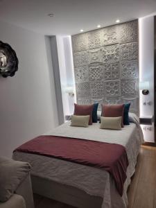 een slaapkamer met een groot bed met 2 kussens bij Andrea`s Home in Benalmádena