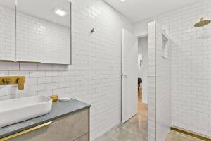 a white bathroom with a sink and a mirror at Salty Crab Bungalow in Lennox Head +14 photos