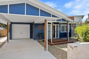 a blue and white house with a garage at Salty Crab Bungalow in Lennox Head