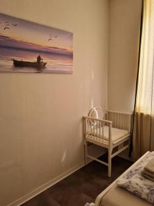 Fuldatal的住宿－Ferienwohnung in Fuldatal bei Kassel，一间设有婴儿床的房间和墙上的绘画