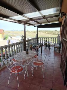 un patio con mesas y sillas en el balcón en Casa Rural Mi Descanso, en Valdefuentes de Sangusín