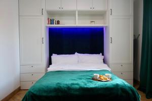 a bed with a blue headboard and a plate of food on it at Widok 3B in Piechowice