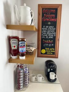 a kitchen with a shelf with cups and a chalkboard at Brewery Farm House Bed & Breakfast in Swindon