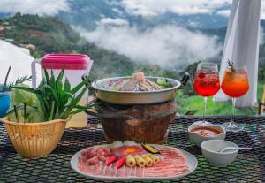 Mon Jamภูตะวัน-บ้านท่าจัน ม่อนแจ่ม的桌子上摆着一盘食物和一杯酒 更多37张照片