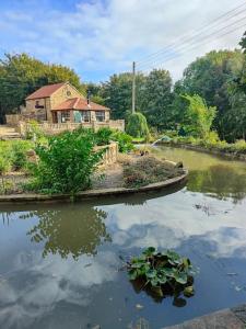 an island in the water with a house in the background at Stunning 2 Bedroom Guest House with Hot Tub in Durham