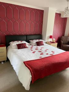 a bedroom with a large bed with a red headboard at Brewery Farm House Bed & Breakfast in Swindon
