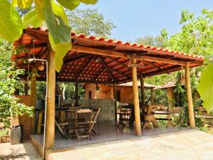 uma pérgola de madeira com uma mesa e cadeiras em Chácara Luz Maria em Pirenópolis