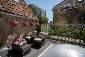 een patio met 2 stoelen en bloemen op een hek bij !!!UNIEK!!! Rijksmonument centrum Harlingen in Harlingen