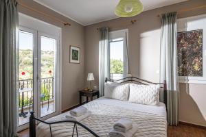 1 dormitorio con 1 cama y 2 ventanas en Gerani Villas, en Gerani