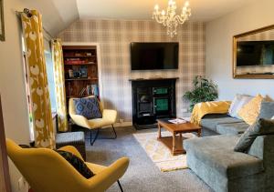 a living room with a couch and a tv at Burnside Cottages in Fettercairn