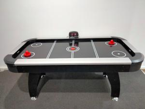 a black and white pool table with two red balls at Modern and cosey 4 bedroom house walk to beach in Saint Leonards
