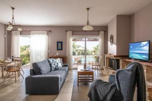 a living room with a couch and a tv at Gerani Villas in Gerani