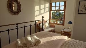 Un dormitorio con una cama, una silla y una ventana en Duplex ORION, en Tazacorte