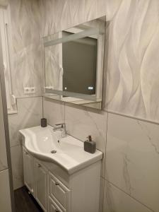 Baño blanco con lavabo y espejo en EBS Paradies, en Rheinhausen