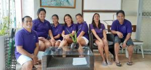 a group of people in purple shirts posing for a picture at MR Holidays Hotel in Boracay