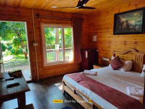 sypialnia z łóżkiem w drewnianym domku w obiekcie Casa Seaesta Beach Cottages and Suites w mieście Arambol