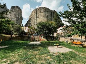 un parque infantil frente a una gran formación rocosa en Elena Guesthouse, en Kalambaka