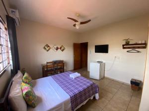 a bedroom with a bed and a tv in it at Chico de Sá Pousada in Pirenópolis