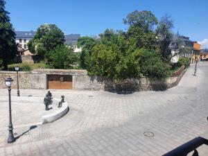 蓬費拉達的住宿－Apartamento en el casco antiguo de Ponferrada，庭院内有两座雕像的石墙