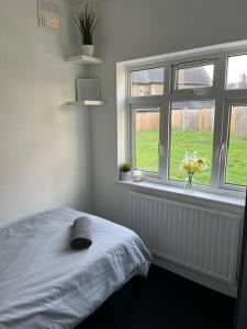 a bedroom with a bed and two windows at Castle Court Apartment in London