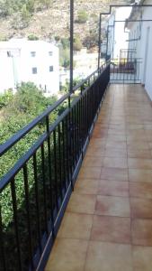 een balkon met een zwarte leuning en een stoep bij Barrero 47 in Igualeja