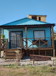 uma casa azul com um sinal em frente em Veniteconmigo em Punta Del Diablo