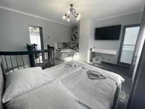 a bedroom with two beds and a flat screen tv at Marea by Baltic Home in Międzyzdroje