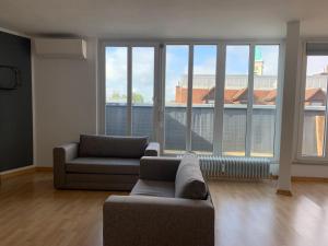 uma sala de estar com 2 sofás e janelas grandes em L8 Street - Monteurwohnung - Zähringerstr em Karlsruhe
