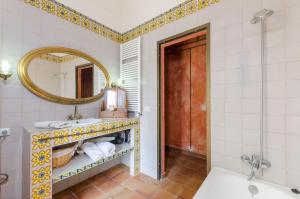 W łazience znajduje się umywalka, lustro i wanna. w obiekcie YourHouse Sa Cova w mieście Petra